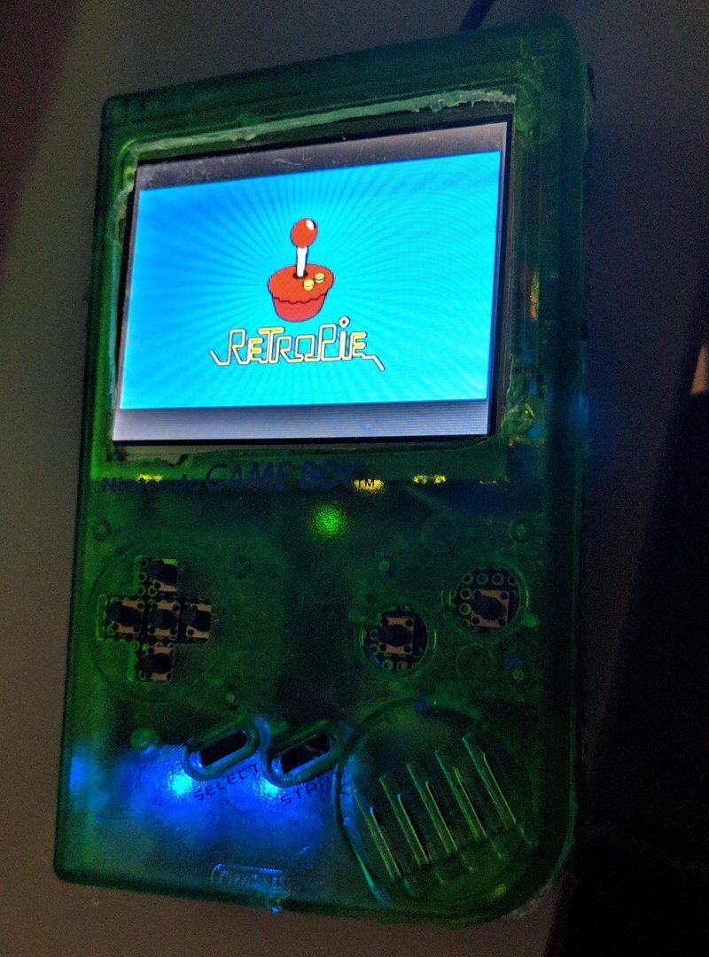 Handheld console in a translucent green shell showing the RetroPie boot screen